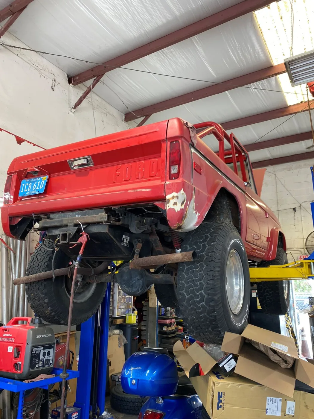 A red classic pickup truck up on the lift